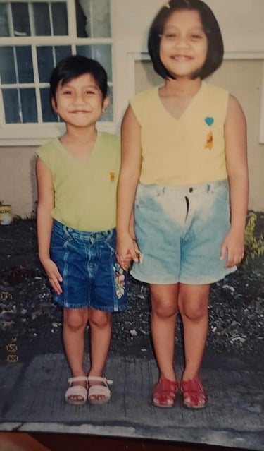 A photo of my young self on the left, holding hands with my older sister on the right.