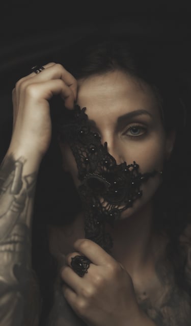 a woman with tattoos on her face and a black mask