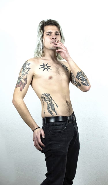 a man with tattoos on his chest, smoks, posing for a photo
