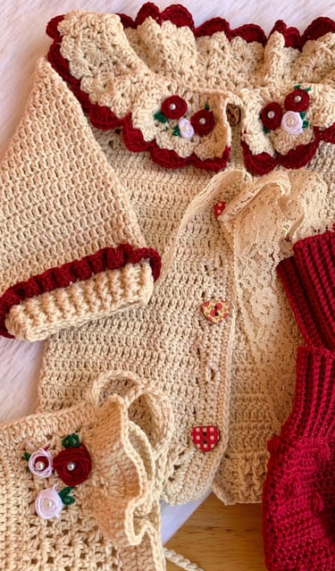 Handmade crochet baby cardigan set in cream and red with floral embroidery and lace details.