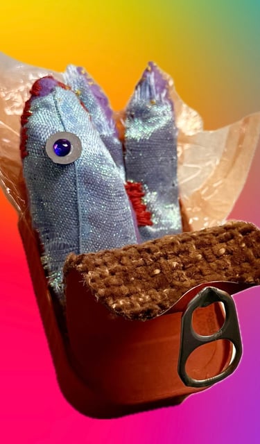 Close-up photo of a sculptor of stitched blue/purple sardine and orange tin with orange foil