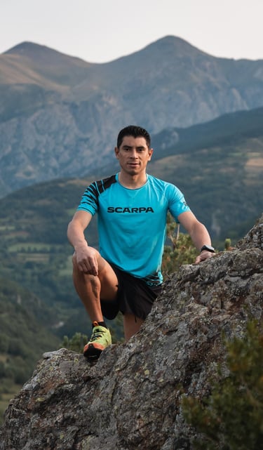 a man in a blue shirt is sitting on a rock