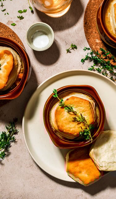 a bowl of soup topped with a biscuit and a bowl of salt