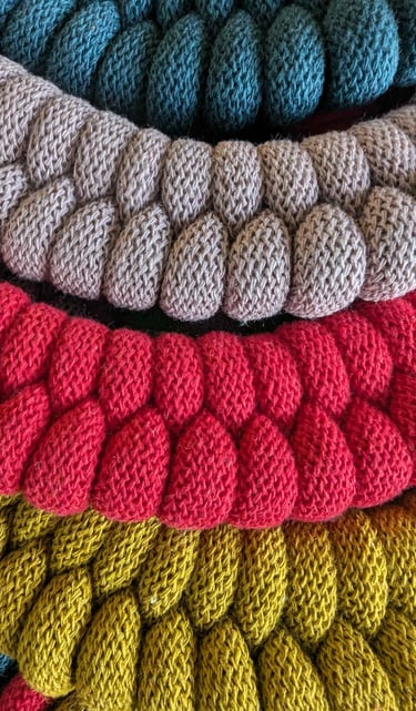 a pile of knitted yarn yarns and yarn