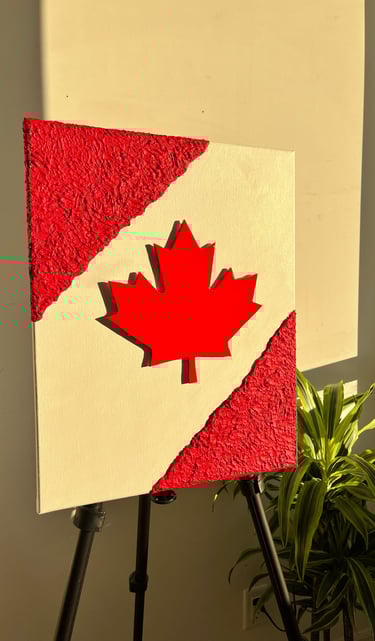 a canadian flag painted on a canvas with a plant in the background