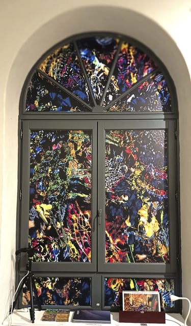Arched window with colorful abstract stained glass film featuring vibrant artistic patterns and textures.