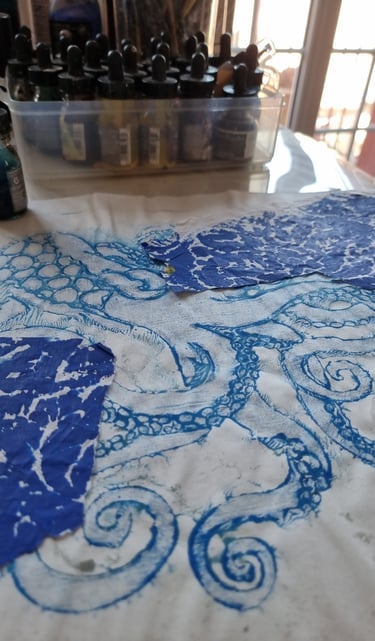 table d'atelier d'artiste montrant une impression de pieuvre sur papier