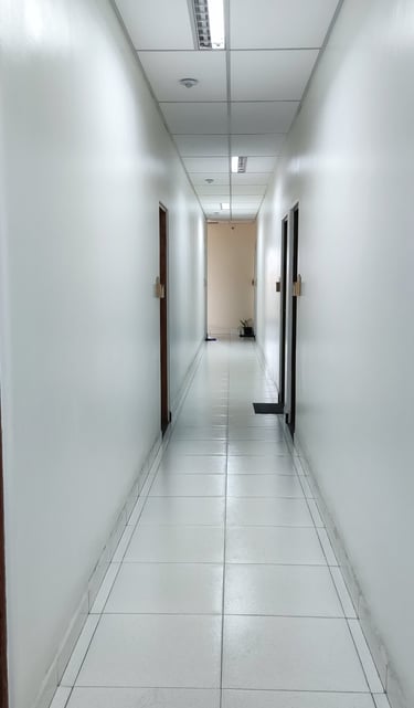 corredor com luminária e forro acústico e removível.