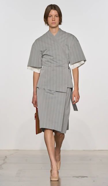 Calvin Klein Spring Summer 2026 runway model in pinstripe wrap skirt suit.