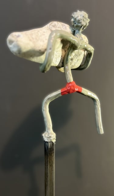 Iron sculpture with stone on iron pedestal