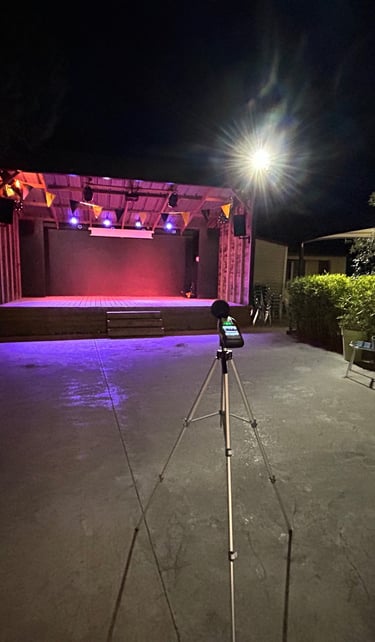 Scène extérieure la nuit avec éclairage violet et un sonometre sur un trépied pour la sur