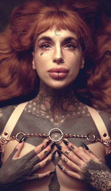 a woman with ginger hair with tattoos on her chest and wearing a harness