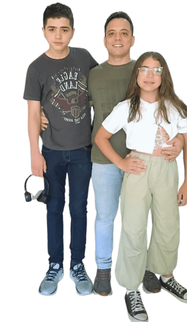 Alan Ochotorena, pai atípico e autista, abraçado com seus filhos adolescentes. Família sorrindo.