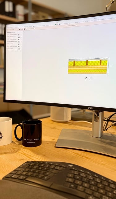 Bureau professionnel à domicile avec un moniteur Dell avec des dessins techniques, une interface aud