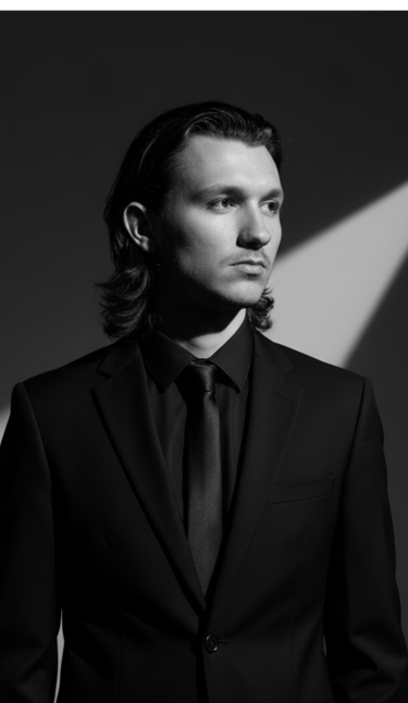 a man in a suit and tie with a light shining through the lens