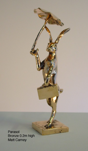 a statue of a rabbit with a parasol and a case