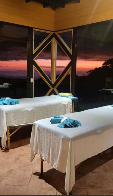 two massage beds in a room with a view of the ocean