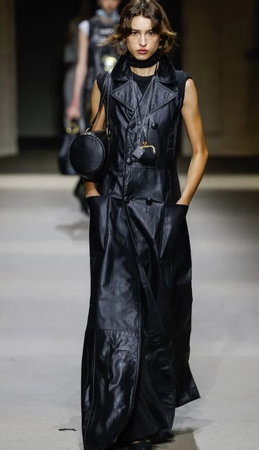 Black leather maxi coat dress with bold accessories at Coach Spring/Summer 2026 show.