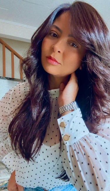 a woman with long hair and a polka dot shirt