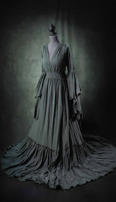 Elegant dark green boho maternity dress with bell sleeves and a flowing skirt on a mannequin.