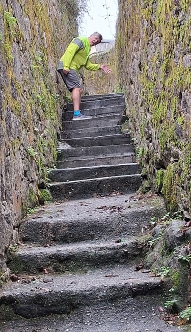 person on narrow steps between high walls