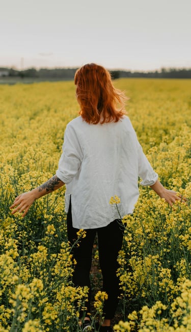 una mujer de pie en un campo de flores amarillas