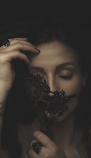 a woman with tattoos on her face and a black mask, eyes are closed