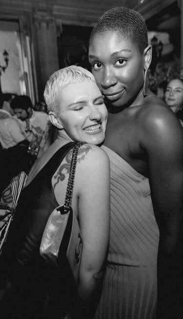 Two elegantly dressed women posing for a photograph in the luxurious interior of a private members c