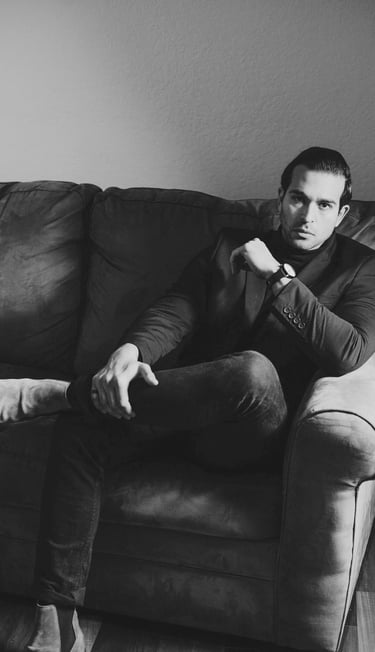 Stylish man seated on a sofa, illustrating the attractive quality of confidence in dating culture