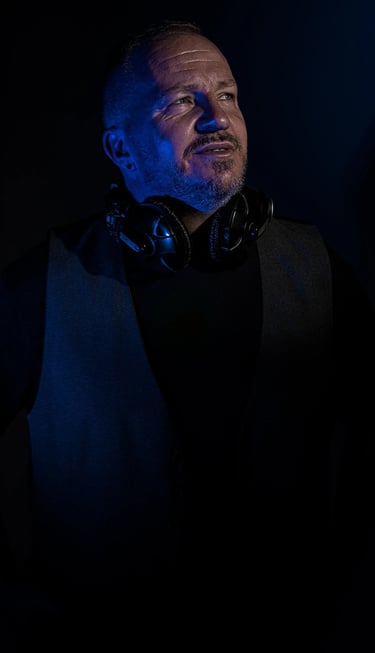 Künstlerporträt eines DJs mit Kopfhörern und kreativem Lichteffekt in Blau, Studioaufnahme Berlin.