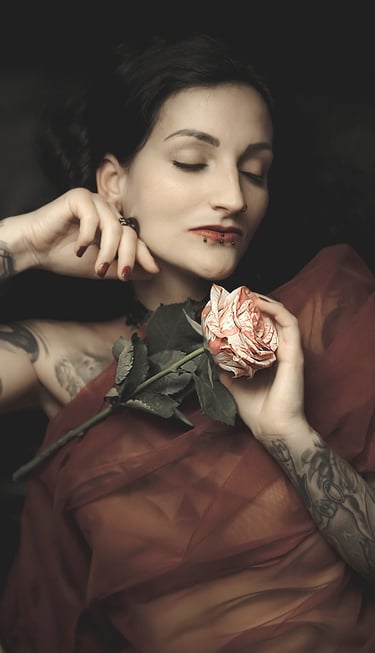portrait of a woman with tattoos on her arm and a rose