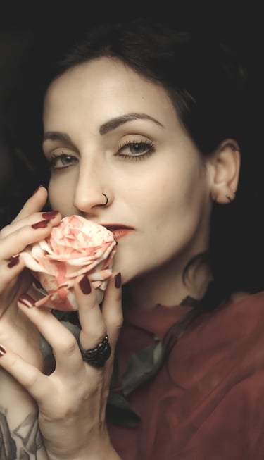 portrait of a woman with tattoos on her arm and a rose