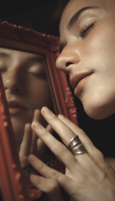 a woman with her eyes closed holding red miror