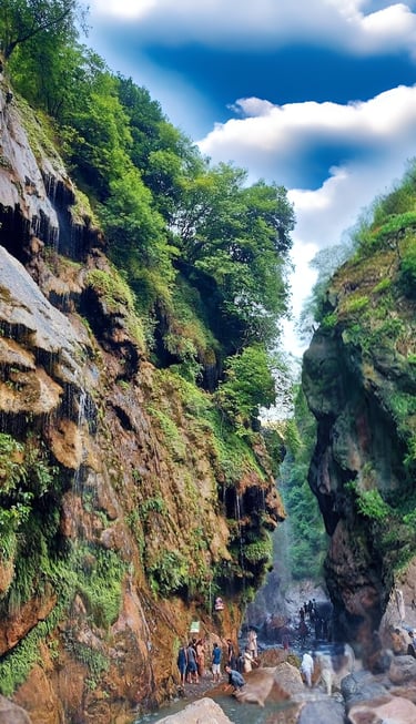 a group of people standing on a mountain side at umbrella waterfall 