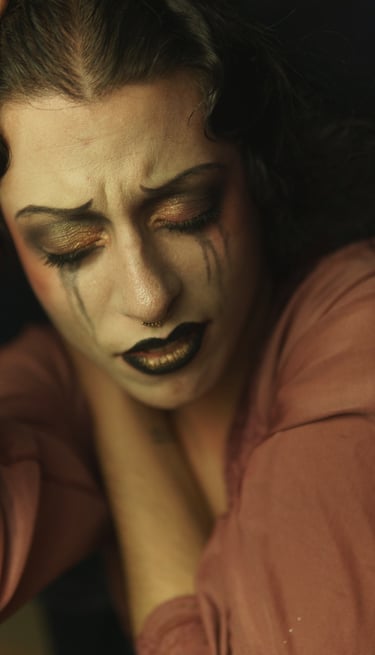 a woman with black makeup and makeup dropping on her face