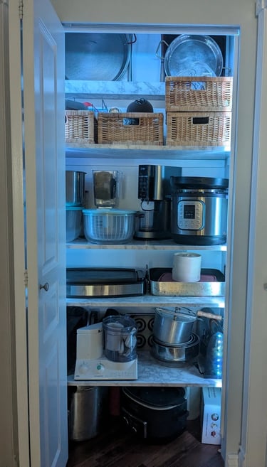 Kitchenware closet, with strip lighting to illuminate deep shelves