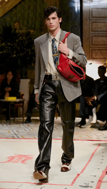 Versace Spring Summer 2026 – Grey blazer with leather trousers and red bag.