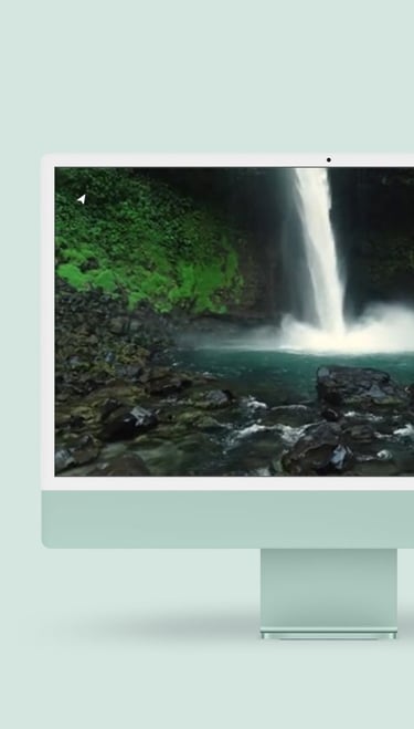 a desktop computer monitor with a waterfall in the background