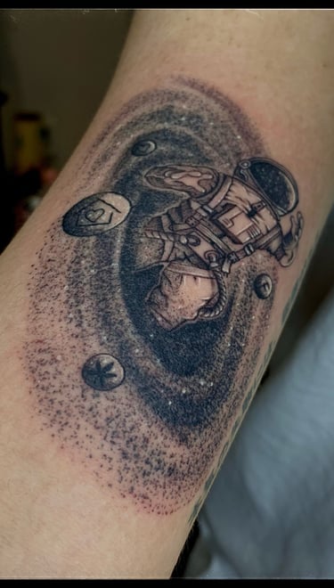 Dotwork tattoo of an astronaut in a black hole with planets