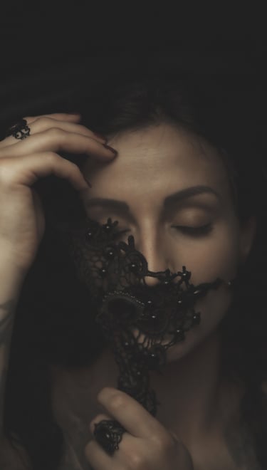 a woman with tattoos on her face and a black mask, eyes are closed