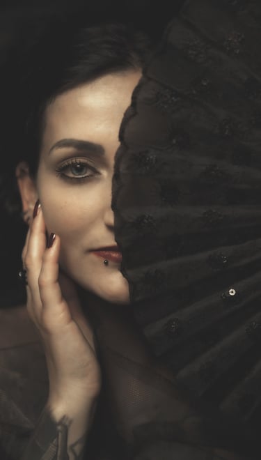 portrait of a woman holding a fan in front of her face
