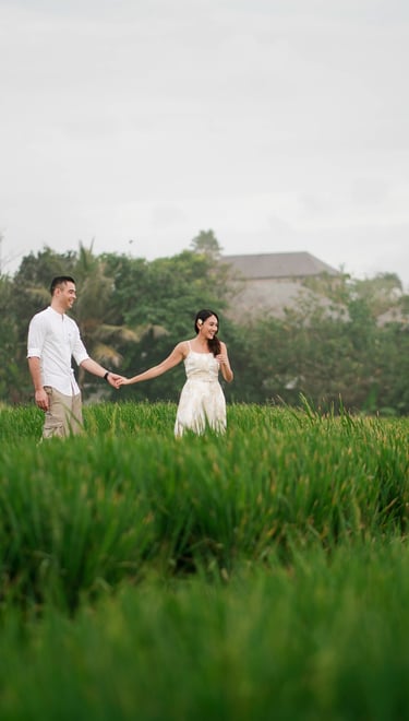 Couple walking through green rice fields at Waka Gangga resort in Tabanan West Bali