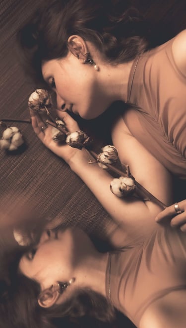 a woman laying on a couch with a flower in her hand and own reflection