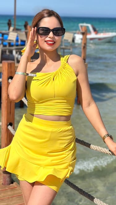 a woman in a yellow dress standing on a pier