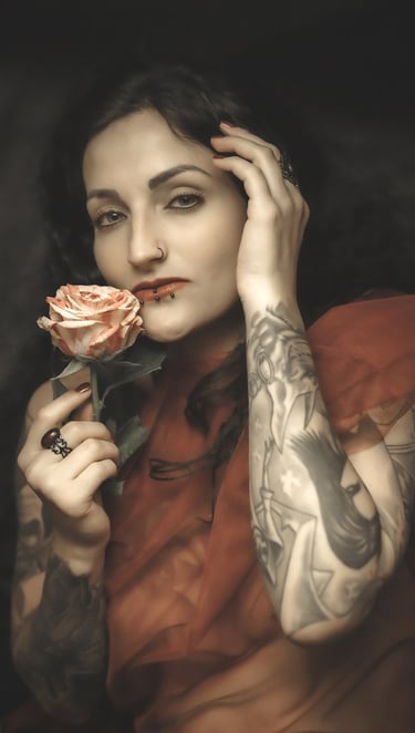 portrait of a woman with tattoos on her arm and a rose