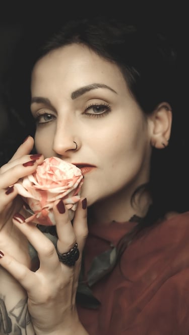 portrait of a woman with tattoos on her arm and a rose