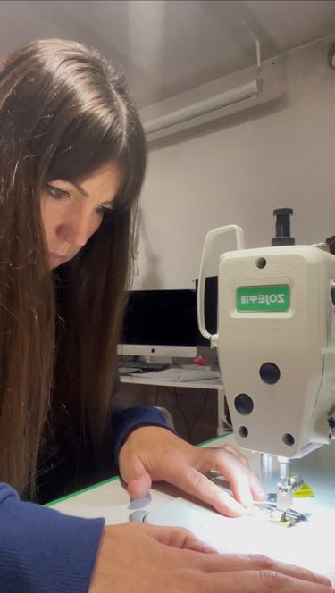 A woman seamstress carefully using an industrial sewing machine in a home design studio.