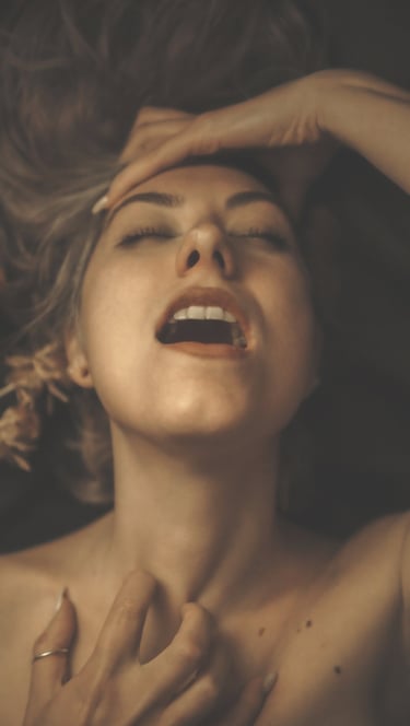 a woman with her eyes closed and mouth open, she holds her hair