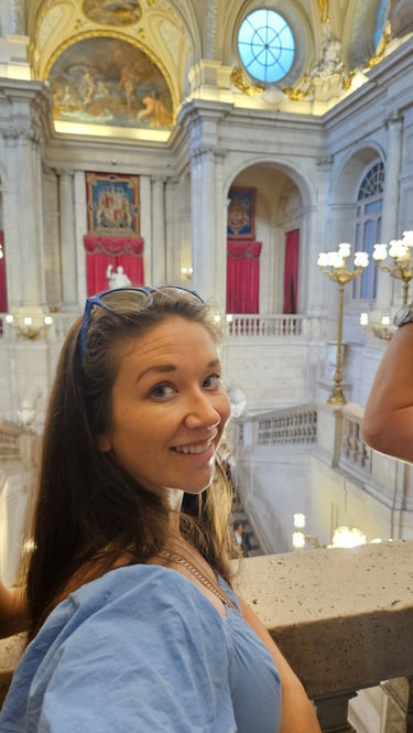 Mom covers shoulders in Spain while visiting historical sites, ensuring proper packing & planning