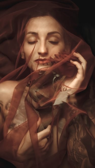 photo of a woman in a red dress with a veil on her head holding a rose